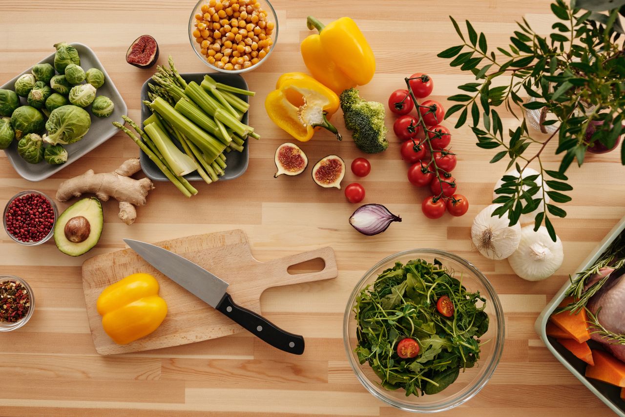 about-us Top view of fresh vegetables and ingredients on a wooden table, perfect for healthy cooking inspiration.